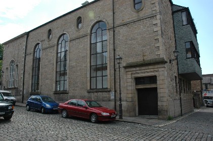 The original arched windows of the nave can still be seen, as can the more ornate windows that show the architectural demarcation of chancel of the Catholic chapel.