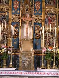 The tabernacle, containing the Blessed Sacrament, with a crucifix above.